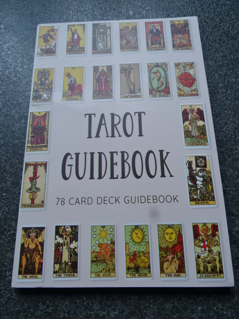 Tarot card guidebook with illustrations on a textured surface